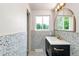 Bathroom with black and white speckled walls, a large mirror, and natural light at 10000 E Ohio Ave, Denver, CO 80247