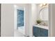 Elegant bathroom featuring a modern vanity with gold fixtures, a stylish mirror, and unique blue tile accents at 10000 E Ohio Ave, Denver, CO 80247