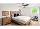 Cozy bedroom featuring a wooden bed frame, hardwood floors, and natural light from the window at 10000 E Ohio Ave, Denver, CO 80247