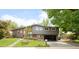 Charming home featuring brick and gray siding, lush landscaping, and a welcoming open carport at 10000 E Ohio Ave, Denver, CO 80247
