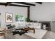 Stylish living room with a stone fireplace, wooden floors, and white sofa complemented by ample natural light at 10000 E Ohio Ave, Denver, CO 80247
