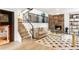 Cozy living room with stone fireplace, adjacent to wooden stairs with a metal railing at 10000 E Ohio Ave, Denver, CO 80247