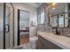 Modern bathroom with decorative tile, glass shower, wood vanity, and updated fixtures at 3947 Winona Ct, Denver, CO 80212