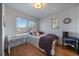 Cozy bedroom with hardwood floors and a clear desk chair by the window at 3947 Winona Ct, Denver, CO 80212