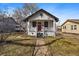 Charming home featuring a red front door, covered porch, and well-maintained lawn at 3947 Winona Ct, Denver, CO 80212