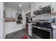 Well-designed kitchen with subway tile backsplash, stainless appliances, and modern grey flooring at 3947 Winona Ct, Denver, CO 80212