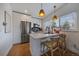 Modern kitchen with white cabinets, stainless steel appliances, quartz countertops, and pendant lighting at 3947 Winona Ct, Denver, CO 80212