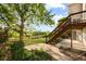 Backyard patio with stairs leading to deck, and green grass at 9453 Lark Sparrow Dr, Highlands Ranch, CO 80126