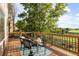 Outdoor deck with wood flooring, black seating, green foliage, and blue sky at 9453 Lark Sparrow Dr, Highlands Ranch, CO 80126