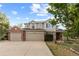 Stately two-story home featuring a three-car garage, a manicured lawn, and brick and siding details at 9453 Lark Sparrow Dr, Highlands Ranch, CO 80126