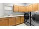 The laundry room has sleek, modern front-loading washer and dryer units with ample cabinetry at 9453 Lark Sparrow Dr, Highlands Ranch, CO 80126