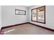 Well-lit bedroom featuring light-colored carpet and baseboard trim at 6025 S Sycamore St, Littleton, CO 80120