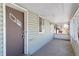 The enclosed front porch with weathered green siding features a secure entrance door, and provides weather protection at 6025 S Sycamore St, Littleton, CO 80120