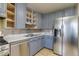 Updated kitchen with stainless steel appliances and gray painted cabinetry at 1881 E 95Th Ave, Thornton, CO 80229