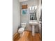 Cozy powder room features wood floors, pedestal sink and a window providing natural light at 2813 Central Park Blvd, Denver, CO 80238
