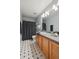 Well-lit bathroom features patterned tile floor, wood vanity with gray countertop and framed mirror at 2813 Central Park Blvd, Denver, CO 80238