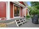 Exterior view features a red home with a front door and porch with gray stairs and stone landscaping at 2813 Central Park Blvd, Denver, CO 80238