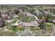 Stunning aerial view of a charming home with a well-manicured lawn and mature trees at 21 Huntwick Ln, Cherry Hills Village, CO 80113