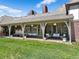 Expansive backyard showcasing a covered patio area, a well-maintained lawn, and the home's architecture at 21 Huntwick Ln, Cherry Hills Village, CO 80113