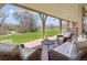 Relaxing covered patio with comfortable seating and views of the expansive lawn at 21 Huntwick Ln, Cherry Hills Village, CO 80113