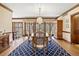 Bright dining room with large windows, a blue patterned rug, and wood trim at 21 Huntwick Ln, Cherry Hills Village, CO 80113