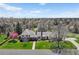 A beautiful view of the home showing the driveway, mature trees, and front yard at 21 Huntwick Ln, Cherry Hills Village, CO 80113