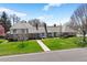 Beautiful home with mature trees, manicured lawn, and brick walkway at 21 Huntwick Ln, Cherry Hills Village, CO 80113