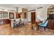 Open kitchen featuring a central island, custom cabinets, and a unique brick accent wall at 21 Huntwick Ln, Cherry Hills Village, CO 80113