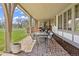 Covered brick patio with an outdoor dining table and a manicured lawn at 21 Huntwick Ln, Cherry Hills Village, CO 80113