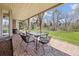 Covered brick patio features outdoor seating and views of the green lawn at 21 Huntwick Ln, Cherry Hills Village, CO 80113