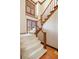 Staircase with carpeted steps, a wooden railing, and a window for natural light at 21 Huntwick Ln, Cherry Hills Village, CO 80113