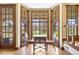 Cozy sunroom with a table and chairs surrounded by large windows at 21 Huntwick Ln, Cherry Hills Village, CO 80113