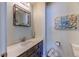 Stylish bathroom featuring a dark vanity with modern sink and faucet, a decorative mirror, and soft blue walls at 23495 Bluestem Dr, Golden, CO 80401