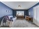 Cozy bedroom with blue walls, soft carpet, a comfortable sofa, and a well-lit window offering a serene view at 23495 Bluestem Dr, Golden, CO 80401