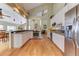 Open kitchen with white cabinetry, stainless steel appliances, wood floors, and a dining area, perfect for modern living at 23495 Bluestem Dr, Golden, CO 80401