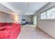 Spacious recreation room with gym equipment, a red couch, and a large window at 23495 Bluestem Dr, Golden, CO 80401