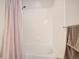 A clean, white bathtub with tiled walls and a shower curtain at 8465 S Holland Way # 101, Littleton, CO 80128