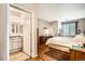 The bedroom features an ensuite bathroom, wood floors, a large window, and neutral tones at 8465 S Holland Way # 101, Littleton, CO 80128