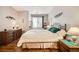 Bright bedroom features wood floors, a queen-size bed, dresser, and natural light from the window at 8465 S Holland Way # 101, Littleton, CO 80128