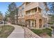 Beautiful condo exterior showing stone accents, balcony, manicured landscaping and handicap accessible sidewalk at 8465 S Holland Way # 101, Littleton, CO 80128