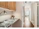 Hallway view featuring built-in desk with granite countertops and cabinet, neutral walls, and wood flooring at 8465 S Holland Way # 101, Littleton, CO 80128