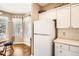 The kitchen has white cabinets, an adjacent dining area, and natural light from a nearby window at 8465 S Holland Way # 101, Littleton, CO 80128