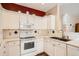 Efficient kitchen with white cabinetry, black backsplash accents, modern appliances, and stainless steel sink at 8465 S Holland Way # 101, Littleton, CO 80128