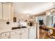 Open-concept kitchen featuring a stainless steel sink, white cabinets, and adjacent living area at 8465 S Holland Way # 101, Littleton, CO 80128