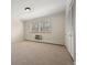 Neutral bedroom with plush carpeting, a built-in air conditioner, and a large window at 3942 E Evans Ave, Denver, CO 80210