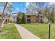Apartment building on a large grassy lawn with mature trees and a walkway at 3942 E Evans Ave, Denver, CO 80210