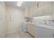Well-lit laundry room with washer, dryer, utility sink, and storage at 3942 E Evans Ave, Denver, CO 80210