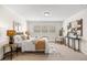 Bright main bedroom featuring hardwood floors, plantation shutters, and a sitting area at 3942 E Evans Ave, Denver, CO 80210