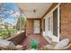 Charming covered porch with brick flooring and comfortable seating at 3942 E Evans Ave, Denver, CO 80210