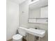 Clean bathroom featuring a toilet, sink, mirror, and cabinet storage at 12885 W Alameda Dr, Lakewood, CO 80228